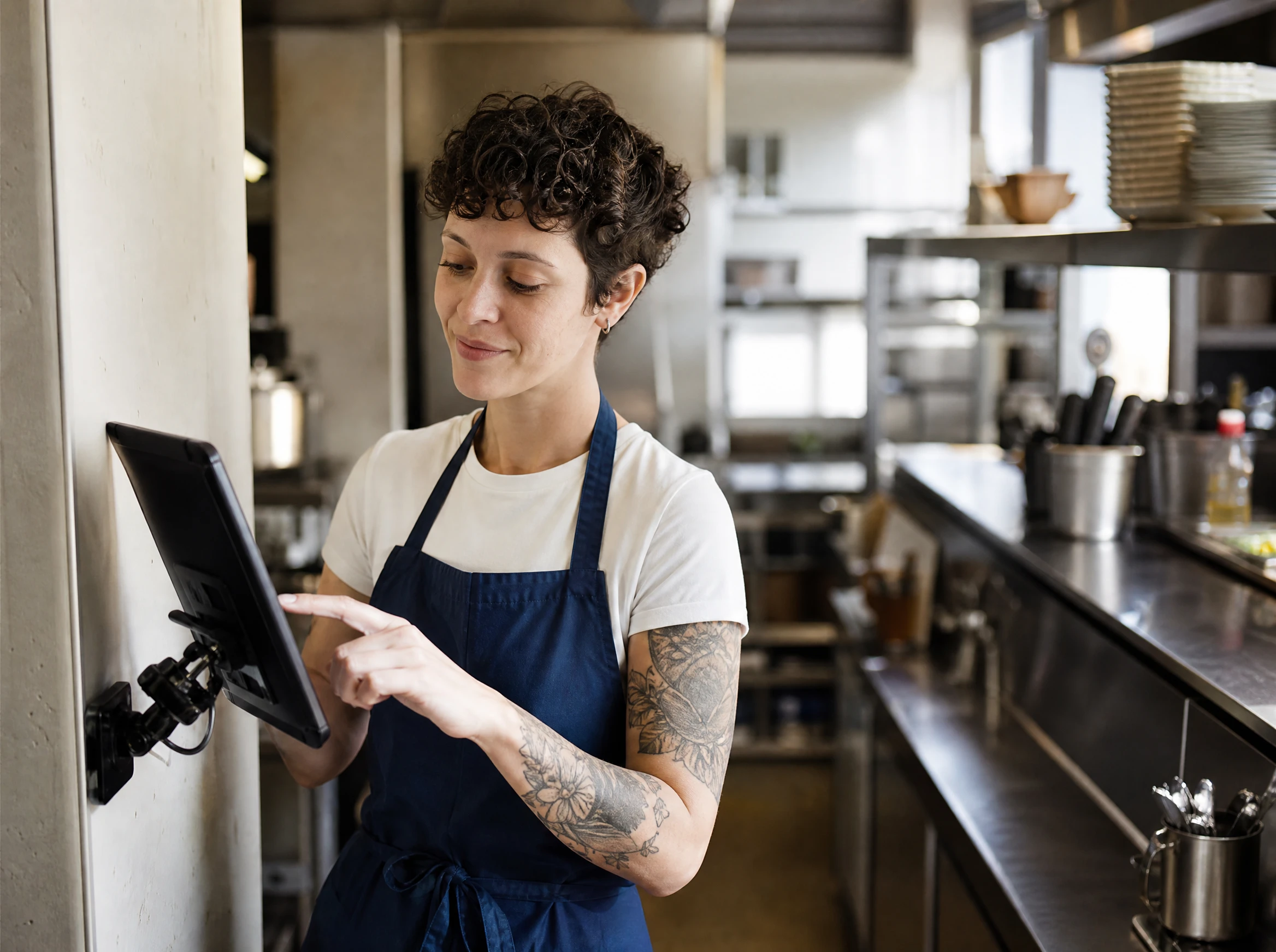 Staf baru berlatih sendirian di tablet yang terpasang di area dapur pada momen yang tenang